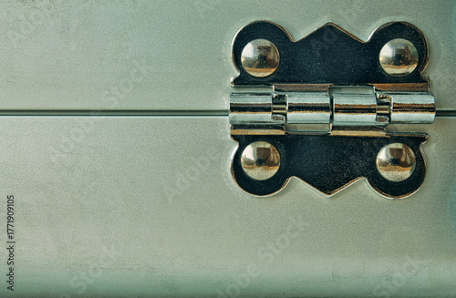 Modern chrome hinge on a textured metal surface. Concept of security, technology, and industrial strength. With copy space for design.