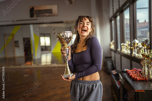 Young woman proudly holding trophy celebrating victory