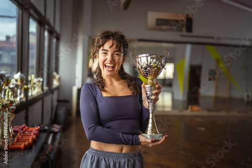 Young woman proudly holding trophy celebrating victory