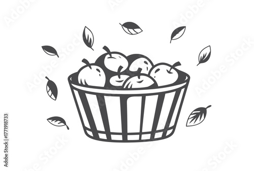 Isolated basket brimming with fresh apples surrounded by falling leaves creates a charming monochrome scene