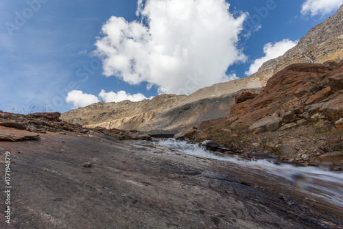 Mountain stream over rocks smoothed by the Vallelunga Glacier with moraines of 1850 age that indicate the enormous retreat of the glacier that occurred due to global warming, Alto Adige, Italy