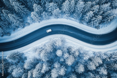 High-angle view of a winding road through a snowy forest, showcasing a solitary white car navigating the winter landscape.
