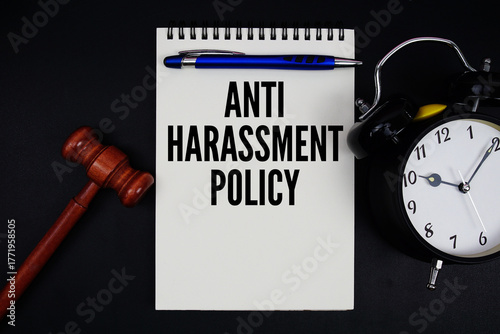 Fotografie Anti-Harassment Policy text written on notepad with gavel and alarm clock on bla