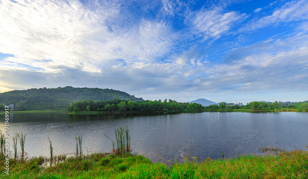 Obraz premium Calm lake with a cloudy sky in the background