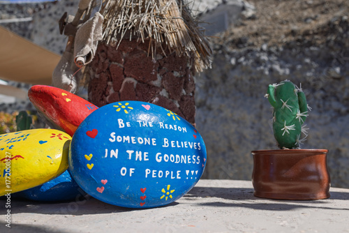 Inspirational painted rock with motivational quote beside small cactus outdoors. Santorini, Greece. 7 October 2025