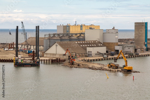 A Dredger Operating & Digging on a Jetty Breakwater in the Harbor of Ronne, Bornholm, Denmark 