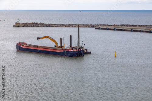 A Flatbed Barge and Dredger Operating in the Harbor of Ronne, Bornholm, Denmark 