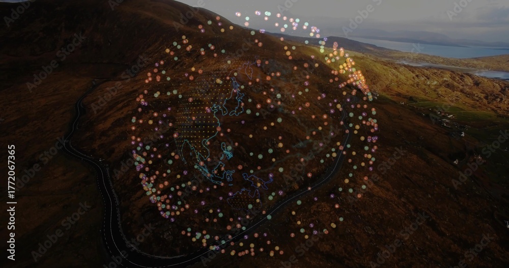 Fototapeta premium Hovering data globe floating above hillside and distant water, with winding road and neon outlines