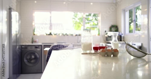 When recording starts, camera is panning across countertop featuring flour jar, eggs for baking