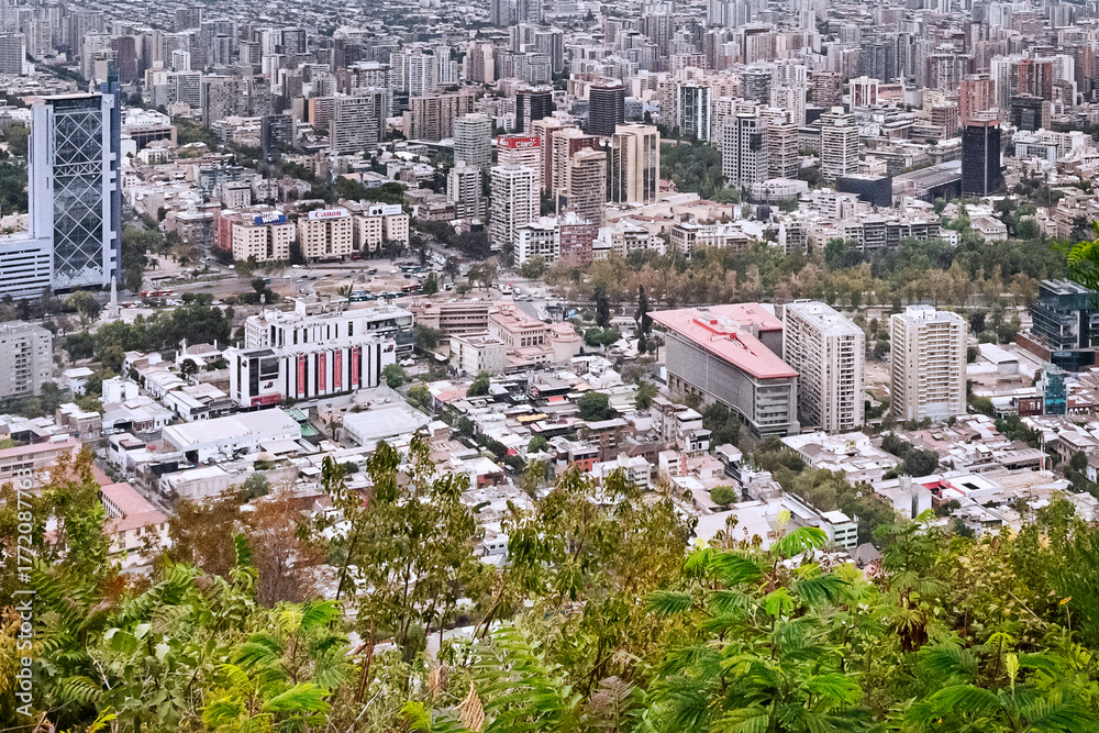 Fototapeta premium Santiago, Chile. 2020. A urban landscape from San Cristobal Hill showing public streets of Las Condes and Vitacura neighborhoods, and the Andes Cordillera's mountains in the background.