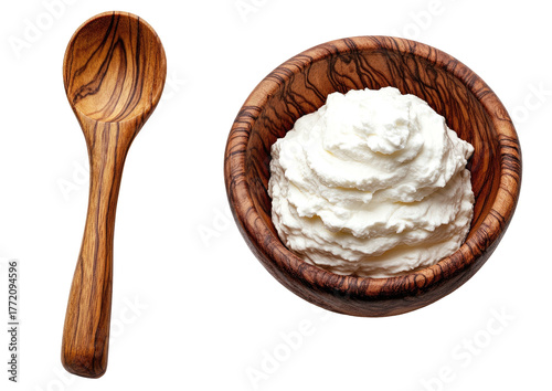 Wooden bowl with cream, spoon alongside