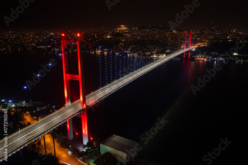 Aerial panoramic drone view of the 15 July Martyrs Bridge (Bosphorus Bridge) at night, connecting Europe and Asia in Istanbul, Turkey