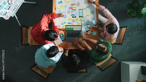 Top view of smart creative project manager using laptop working on Ux Ui design for mobile phone interface while marketing team designing software program by using brainstorming mind map. Convocation.