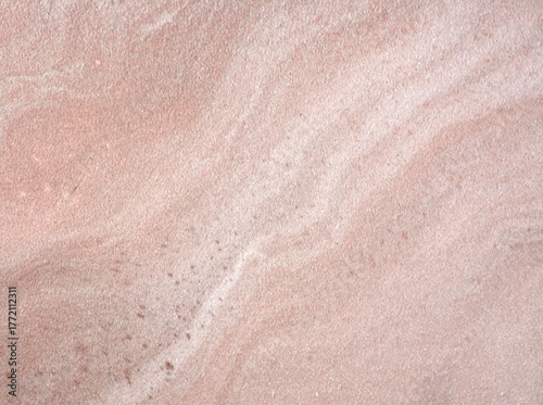 Pink marble, a close-up of the wavy pattern of natural stone with inclusions.