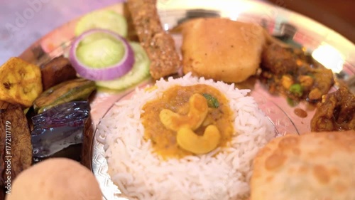 A close-up shot of a delicious Indian thali meal featuring rice, curry, bread, and various side dishes.