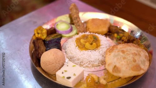 A plate of traditional Bengali cuisine with rice, vegetables, and sweets.