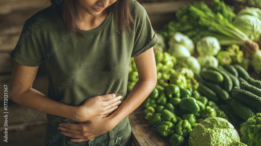 Obraz premium Young woman clutching her abdomen amidst a display of fresh green produce