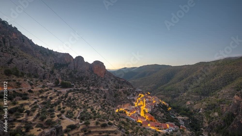 Timelapse of Ayna Village lights glow in mountain valley at dusk.