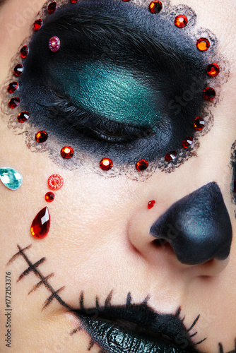 Halloween beauty close-up photography of female face with closed eyes. Santa Muerte makeup.