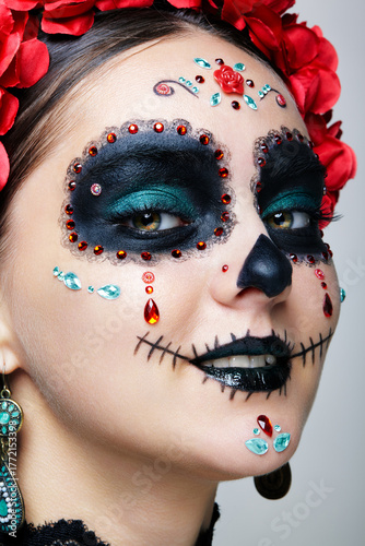 Halloween beauty close-up photography of female face. Woman adorned with Santa Muerte makeup.