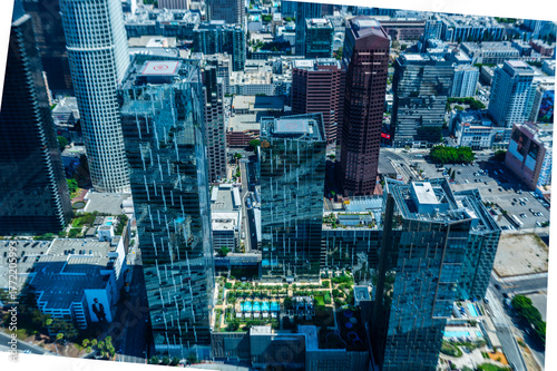 Drone aerial photo of skyscrapers in downtown Los Angeles California featuring PwC Tower and surrounding office buildings under clear blue sky on a sunny day