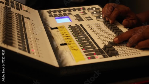 Slide shot of a sound producer hand is using a music mixer with editing tools in a professional recording studio.
