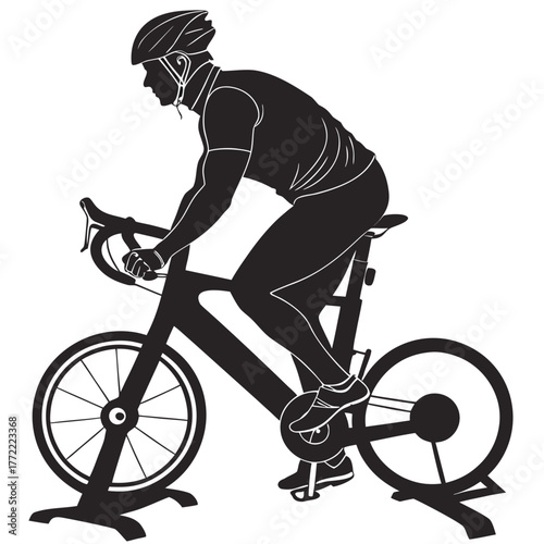 Silhouette of a male cyclist wearing a helmet and cycling gear riding a stationary bicycle indoors for training and exercise