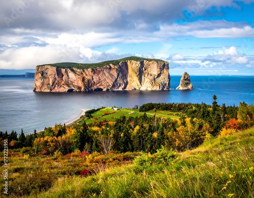 Large rock formations jut out of the sea under a cloudy sky