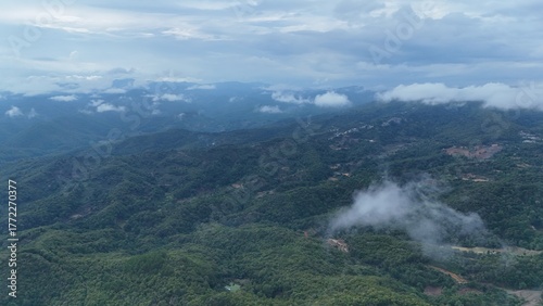 Green mountain valley landscape in Kunming,Mountains and clouds in Kunming, Yunnan,Natural mountain scenery in Kunming,Kunming valley surrounded by green hills,Misty mountain forest in Kunming