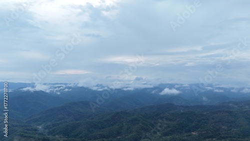 Green mountain valley landscape in Kunming,Mountains and clouds in Kunming, Yunnan,Natural mountain scenery in Kunming,Kunming valley surrounded by green hills,Misty mountain forest in Kunming