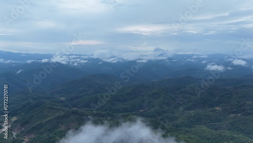 Green mountain valley landscape in Kunming,Mountains and clouds in Kunming, Yunnan,Natural mountain scenery in Kunming,Kunming valley surrounded by green hills,Misty mountain forest in Kunming