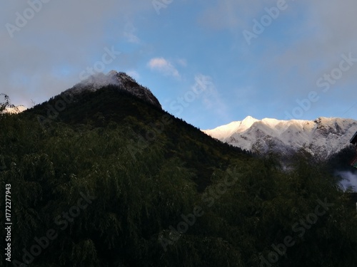 Tibetan plateau village under snowy mountains,Snow-capped mountains, blue sky and Tibetan houses