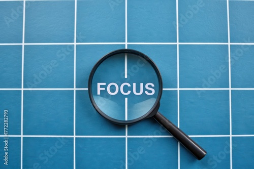 Magnifying Glass Over Text Focus on Blue Grid Background