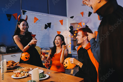 Canvas Print Joyful office Halloween party with coworkers in costumes, celebrating with drink