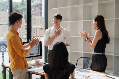 Young team congratulating colleague for success and achievement
