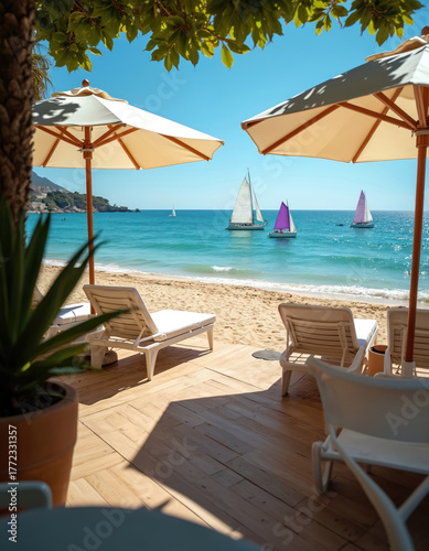 Wallpaper Mural Sunny beach with lounge chairs under umbrellas. Sailboats on blue ocean water near sandy shore. Mountainous coastline visible afar. Clear sky brightens summer day. Torontodigital.ca