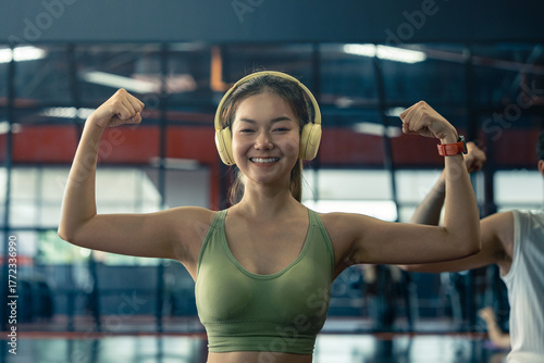 Preparing for the exercises. Doing streching. Young Asian woman in sportive clothes have fitness day in the gym.