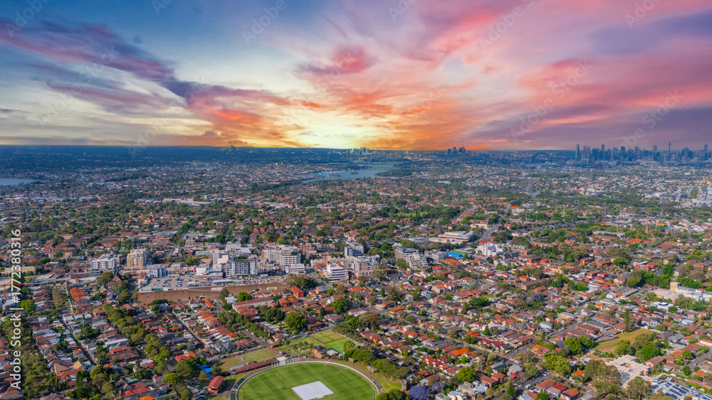 Fototapeta premium Panorama Sunset aerial drone view of western Sydney Suburbs of Canterbury Burwood Ashfield Marrickville Campsie with Houses roads and parks in Sydney New South Wales NSW Australia