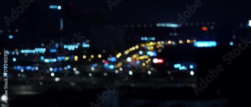 Defocused night cityscape with glowing urban lights and soft bokeh, creating a moody atmospheric background suitable for design, advertising and abstract visuals