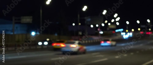 Defocused night highway scene with moving car lights and glowing bokeh, creating a cinematic abstract background suitable for design, advertising and motion graphics