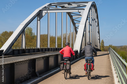 Cyclists ride on the cycle path on the arch bridge over the IJssel near Doesburg in the Achterhoek.