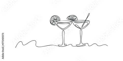 Two cocktail glasses with lime slice and straw