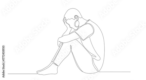 A person sits alone with their head in their hands in a moment of distress.