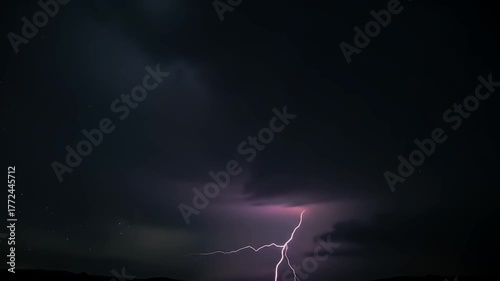 Dramatic Purple Lightning Bolt Illuminates Dark Stormy Clouds Over Silhouetted Cityscape at Night
