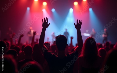 Silhouette of people raise hand up in music concert with red and blue color spotlight on stage background. High quality