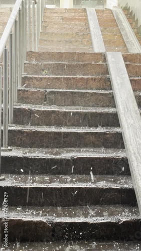 hail and rainwater roll down the stairs. Hail and rain in the city