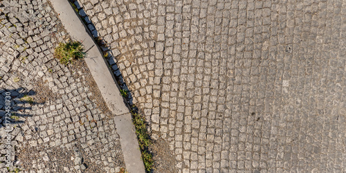 top view of the texture sidewalk or road paved with large stones or cobblestones on pedestrian path