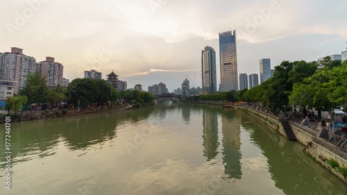 Sunset timelapse of traditional Chinese bridge over river in Chengdu with glowing evening sky