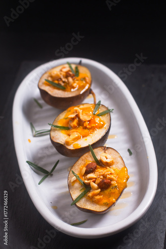 Roasted Pears with Blue Cheese nuts and Honey on black background with copy space