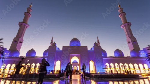 Wide-angle timelapse of Sheikh Zayed Grand Mosque at sunset with glowing domes and dramatic sky